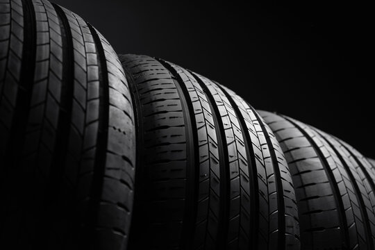 Car tires on a dark background. Close up view of new summer tire tread. Low angle view