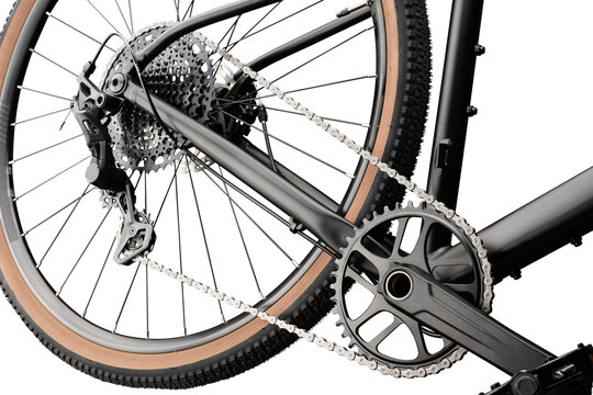 Close-up of a gravel bike. Cassette, chain, crankset and tan wall tire, isolated