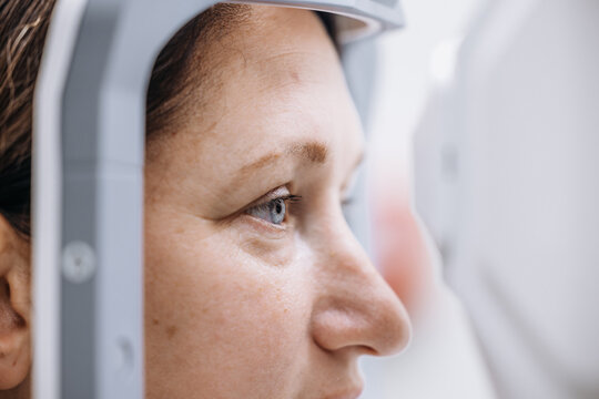 Woman during retinal examination with optical coherence tomography scanner. Concept ophthalmology, eye diagnostics and modern medicine.
