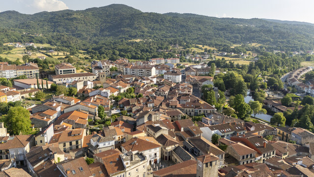 Aerial view of the historic town of Allariz with its dense terracotta rooftops, narrow streets, and lush green hills in Allariz, Province of Ourense, Spain.