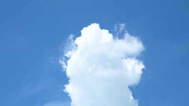 blue sky with A lone white cloud floating in the bright blue sky background.clouds