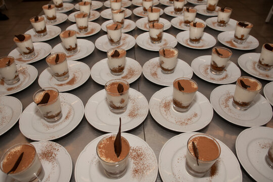 Mesa llena de postres listos para servir en vasos 