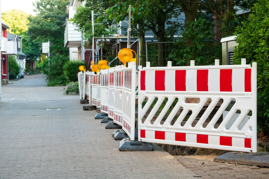 Red and White Plastic Road Barriers Blockading Street Trench - The Concept of Urban Infrastructure Maintenance