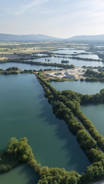 Aerial view of Lagoa da Lontra featuring interconnected water bodies, lush green vegetation, and surrounding agricultural fields in Sandias, Ourense, Spain.