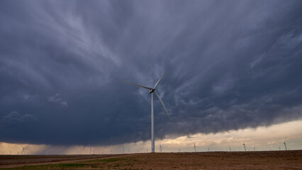 Wind turbine under dramatic storm clouds during severe weather © Frank