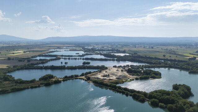 Aerial view of Areeiras da Limia featuring turquoise water pools and sand extraction areas surrounded by lush vegetation in the rural landscape of Ourense, Ourense, Spain.