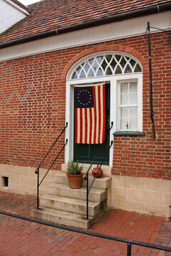 An early American flag is hanging on a door in Old Salem Historic District, Winston-Salem, North Carolina