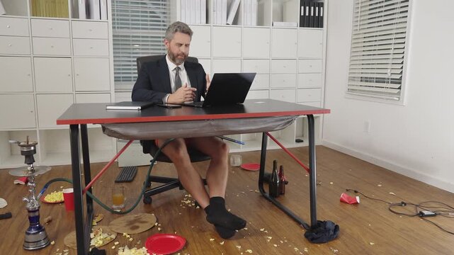 Business man working in a messy workplace. Comic freelancer enjoying a crazy remote office. Funny man surrounded by business mess at home. Messy workplace shows crazy business humor.