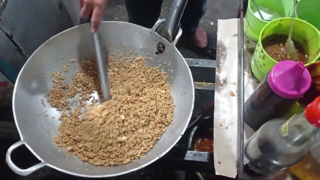 A Close-up of a chef cooking Peruvian shrimp fried rice in a big pan
