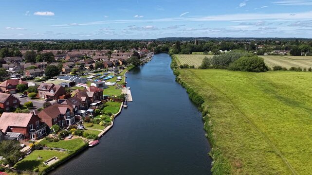 Aerial drone footage of Abingdon outskirts and the River Thames in Oxfordshire, England, showing riverside landscapes, countryside, residential areas, and flowing waterways on a bright summer day