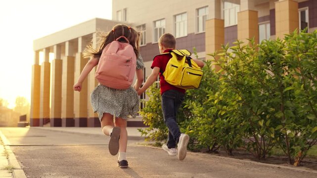 School journey for children, Happy kids on sidewalk, Students heading to class, Back-to-school season, Sunrise at school building, Hand in hand friendship, Little learners arrive, Kids&rsquo; morning walk