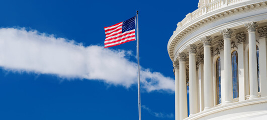United States Flag Flying Beside US Capitol Dome Under Blue Sky © kosoff