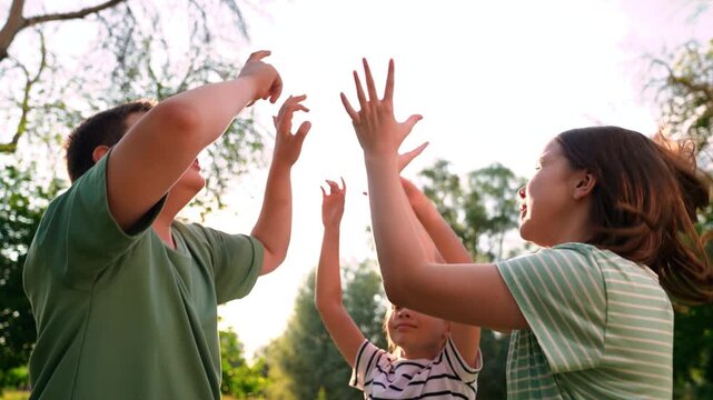 Happy children playing playground, children hands sun glare nature, boy girl friends playground, playful kids circle game in summer greenery, bright summer evening with playful children, energetic