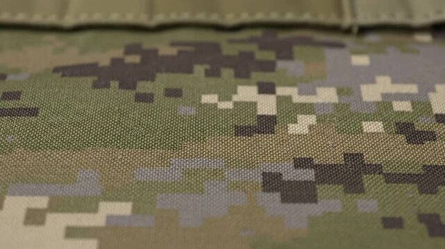 Close up view of digitally patterned camouflage fabric with a tactical aesthetic, showcasing durability