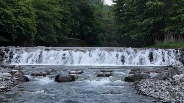 Waterfalls tumble over rocks in a forested stream. Rivers rush beneath a small dam, surrounded by greenery. Trees frame the scene, creating a serene, natural backdrop