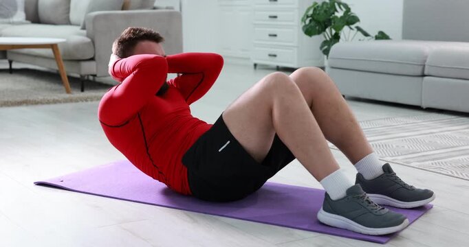 Man doing exercise on fitness mat at home