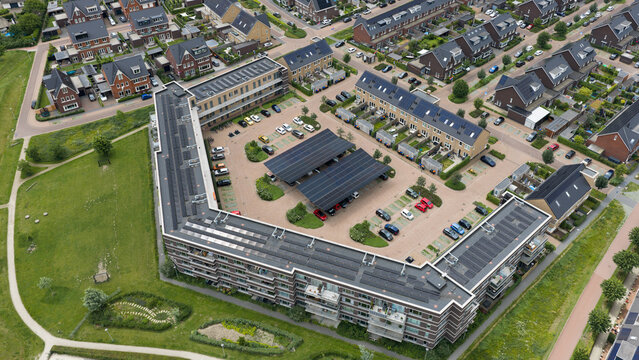Aerial drone view of a solar carport generating renewable electricity, protecting parked vehicles and supporting electric charging and sustainable mobility.