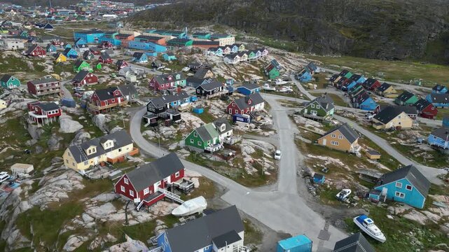 Aerial view of Ilulissat Icefjord featuring colorful wooden houses scattered across the rocky arctic landscape in Avannaata Kommunia, Greenland.
