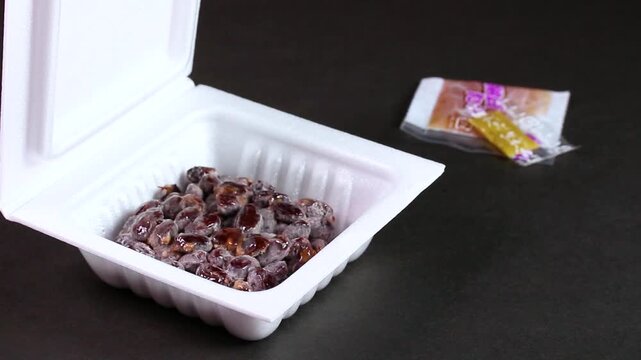 パックに入った黒豆納豆とタレの回転映像