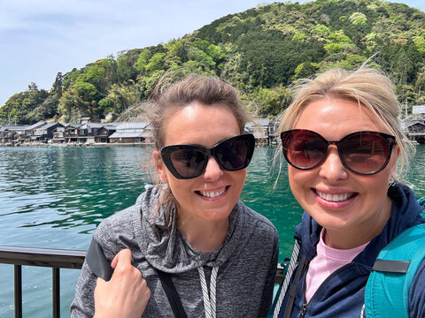 Two happy American tourists smile at Ine Bay Fishing Village in Kyoto Prefecture Japan
