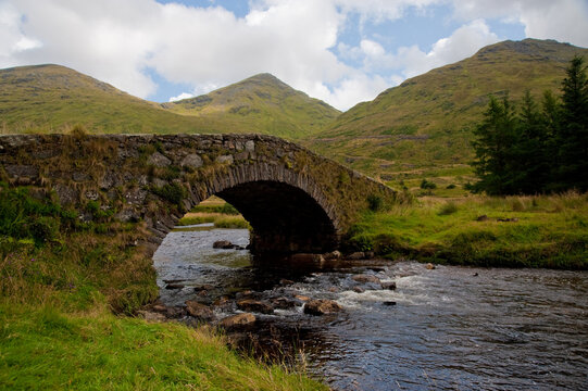 Title: Historic Stone Footbridge in the Scottish Highlands Mountain Valley
