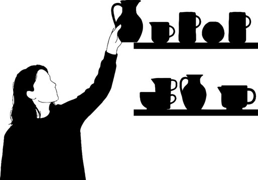 Silhouette of person arranging pottery on shelf.