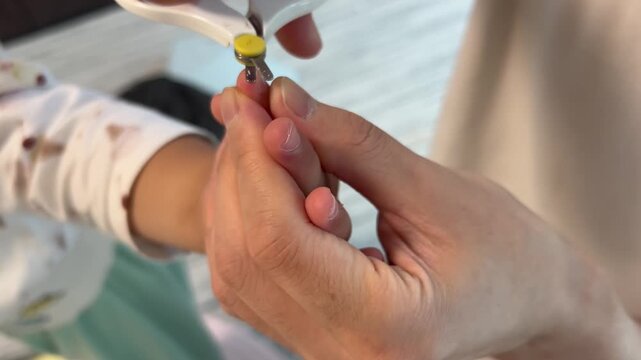 子供の爪を切る親