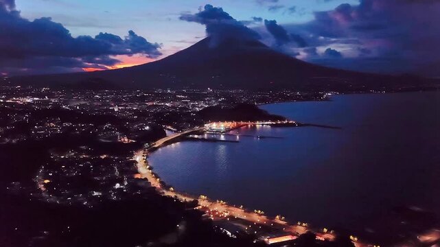 Drone aerial view of Legazpi City Boulevard at sunrise with majestic Mayon Volcano backdrop and dramatic clouds, Albay