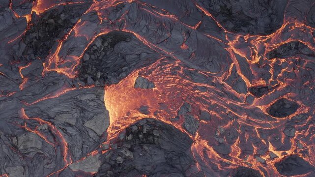 Aerial view of molten lava flowing across dark volcanic rock formations in Reykjanesbaer, Iceland.