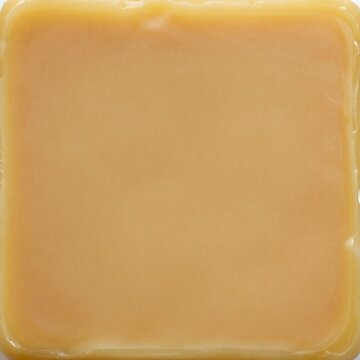 Smooth beeswax texture background with warm golden cloudy swirls and matte sheen