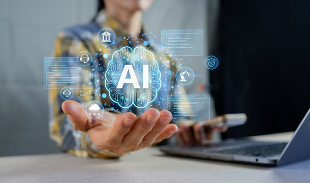 Hand holding glowing AI brain icon with digital interface and machine learning data on laptop.