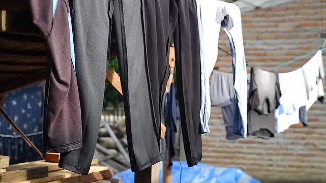 Close up of clothes hanging on a laundry line drying and swaying gently in the wind