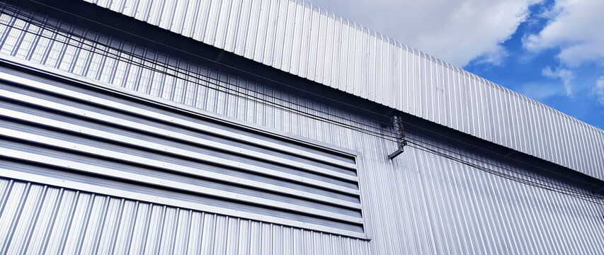 Metal sheet roof curve on blue sky. Modern construction, Metal ribbed arch span roof covering, Large building roof. not ai