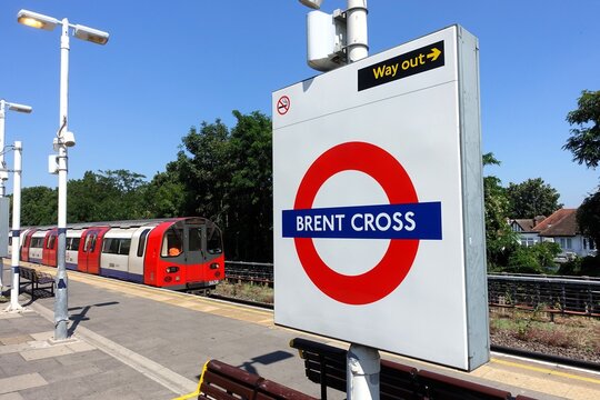 The sign for the London Underground at Brent Cross station, on the Northern Line, showcases the traditional roundel design consisting of a red circle and blue bar against a white backdrop.