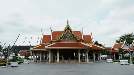 Obraz premium Wide Panoramic Front View Traditional Thai Temple Main Hall Vast Empty Stone Plaza