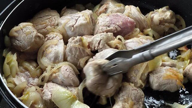 Close-up of pork and onions braised in a rich soy sauce mixture.