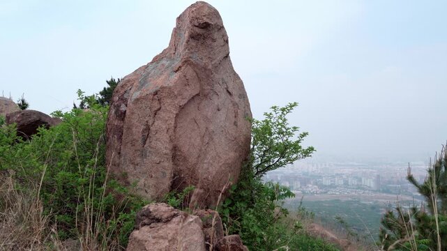 This rock stands at the top of the slope, with a wild jujube tree growing at its base; the small town below lies to the lower right.