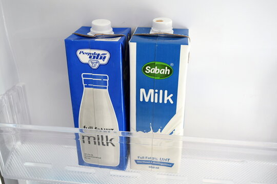 Two cartons of Pegah and Sabah UHT milk on a shelf inside a refrigerator 