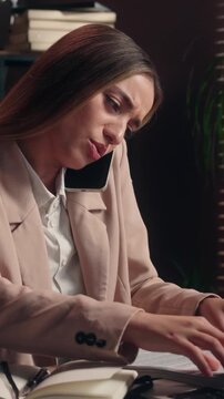 Dissatisfied Caucasian business woman leader with papers searching contract talking mobile phone female girl businesswoman project founder talk stressed search file stats documents throwing in office