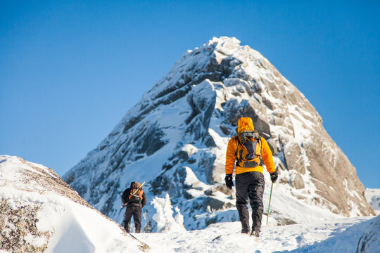 Rear view of two Mountaineers approaching summit