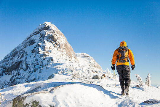 Hiker walks toward a snowy mountain peak