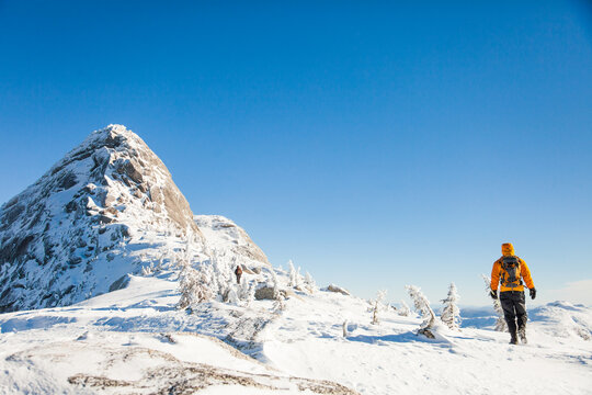 Person hiking on a snowy mountain on a sunny day
