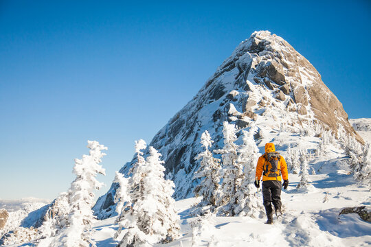 Man hiking towards a snowy mountain peak