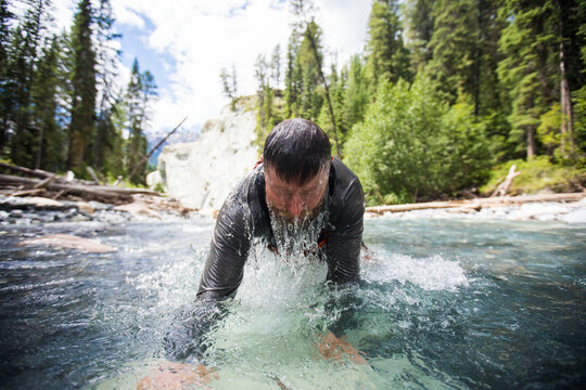 Man emerges from a cold mountain river
