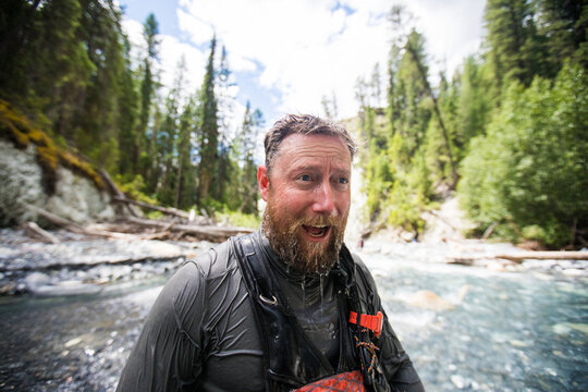 Exhilarated man emerges from a cold mountain stream