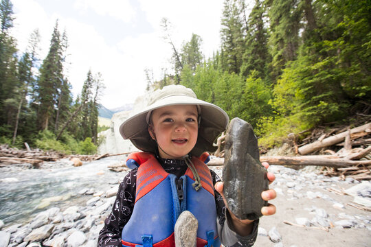 Happy boy proudly shows off his river rock