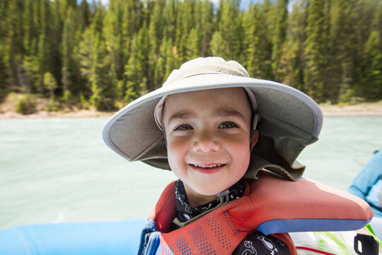 Young boy in a life vest enjoying a sunny day on the river