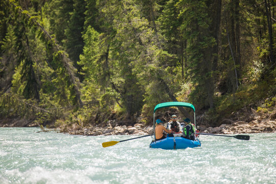 Group of friends rafting down a scenic river