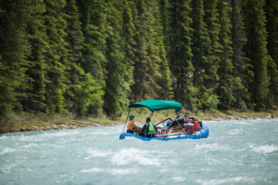 People navigate a blue raft on a mountain river