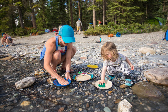 Mother and child washing dishes while camping